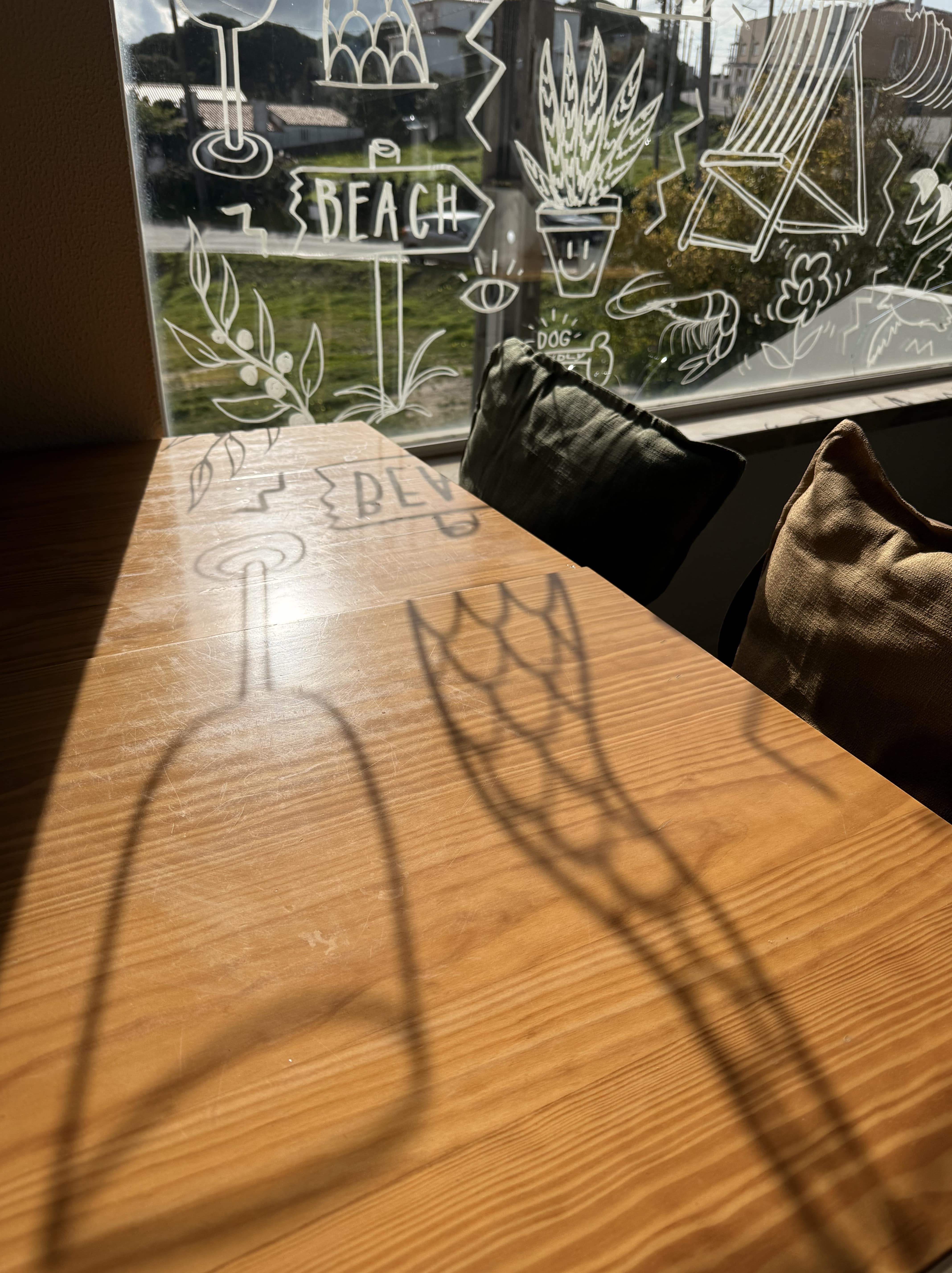 Zone de sièges intérieure avec beaucoup de lumière naturelle au restaurant Amor Meco à Aldeia do Meco